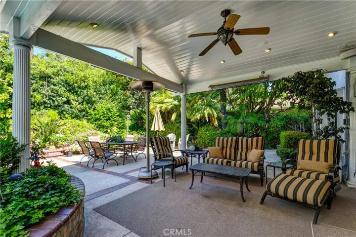 Covered patio with a ceiling fan and electric heaters