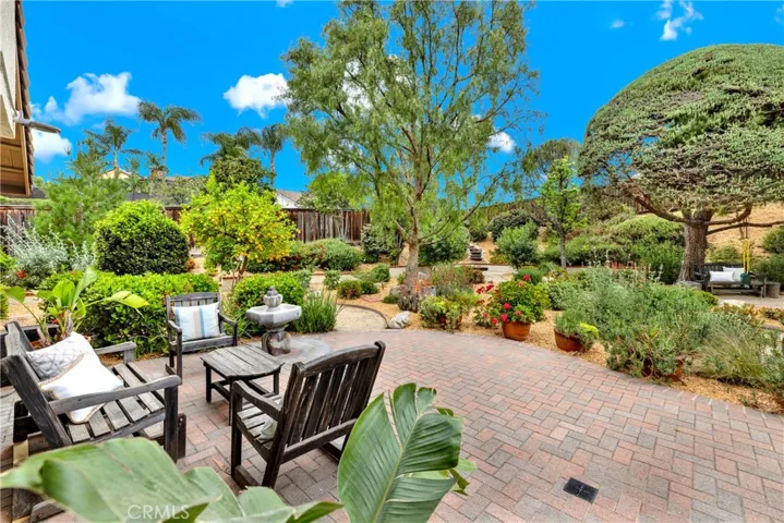 Step into a private oasis where lush landscaping, a tranquil fountain, and cozy seating areas create a peaceful escape right in your own backyard.