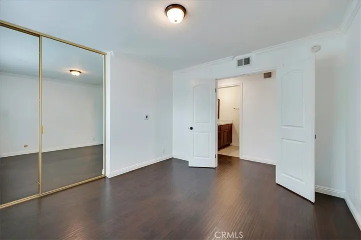 Front bedroom with double door entry & mirrored sliding closet doors. Window facing private and secure front patio area.