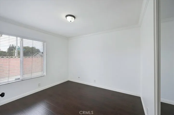 Large bedroom facing front patio providing security and privacy. Mirrored closet doors.