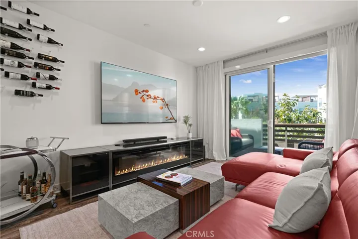 Light-filled family room opens to a sunny balcony—perfect for relaxing by day, with custom shades for cozy movie nights.