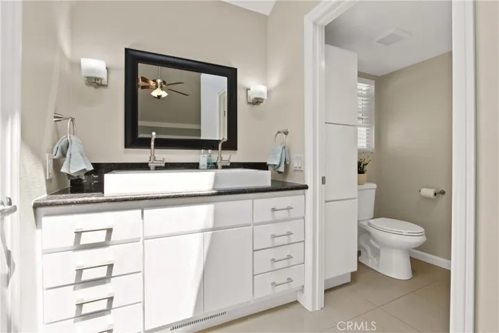 Bathroom sink with dual faucets, lots of storage in vanity and in toilet area as well.  Walk-in closet is to the left of vanity.