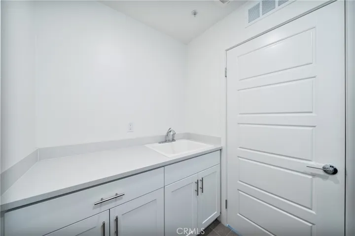 Main level laundry room sink and cabinets.