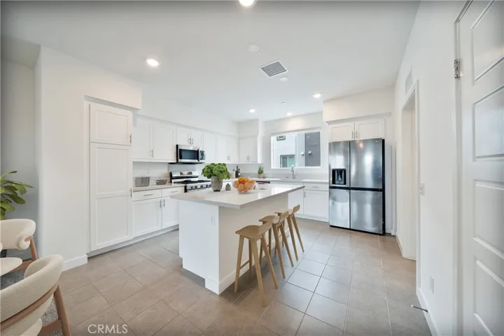 Gourmet kitchen with stainless steel  appliances, plenty of cabinetry and pantry space-digitally staged.