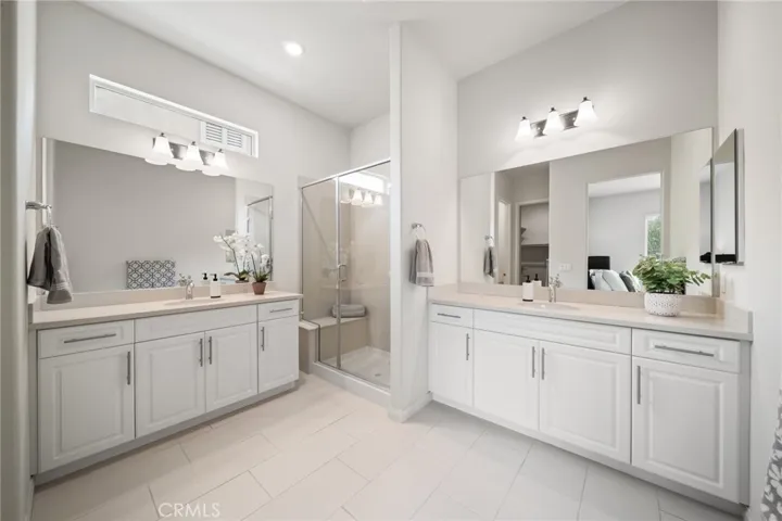 Spacious Primary Bathroom with Dual Vanities and Glass-Enclosed Shower