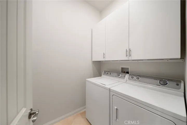 Laundry Room with Washer, Dryer, and Overhead Storage Cabinets