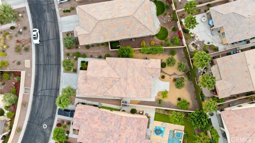 Overhead View of the Property Showcasing Rooflines, Driveway, and Spacious Desert-Landscaped Backyard