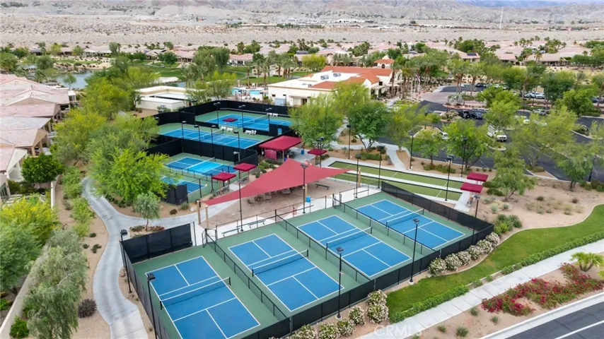 Community Amenity Center Featuring Multiple Pickleball and Tennis Courts, Clubhouse, and Lush Landscaping with Mountain Views