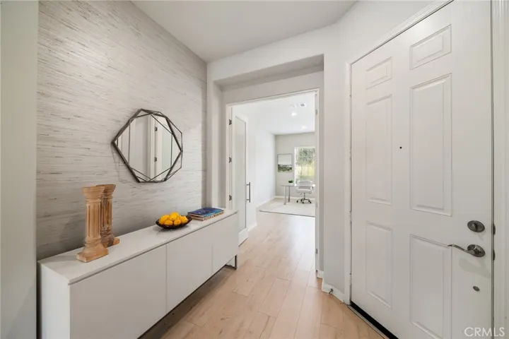 Welcoming Entryway with Statement Wall and View into a Bright Home Office