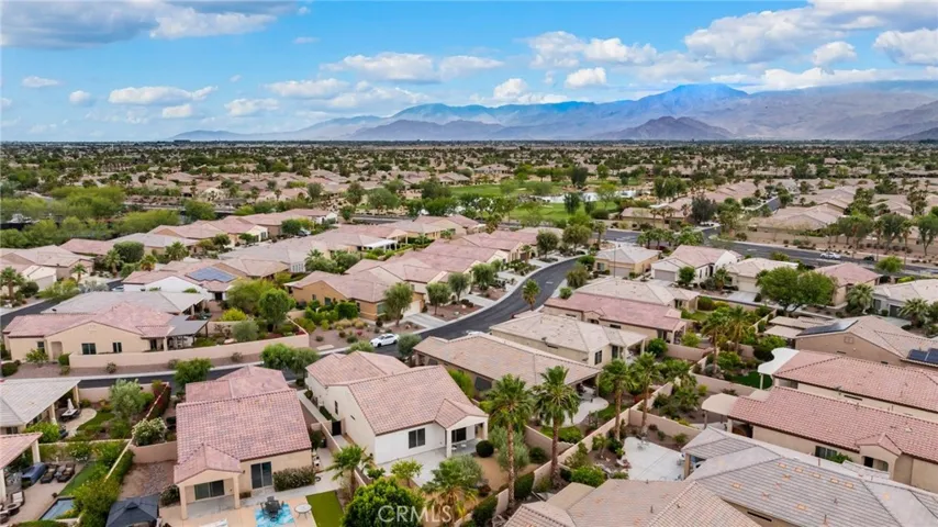 Sweeping Aerial Perspective with Clear View of the Golf Course and Majestic Mountain Range in the Distance