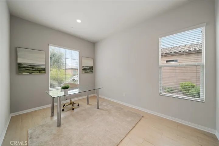 Light-Filled Home Office with Dual Window Views and Modern Glass Desk