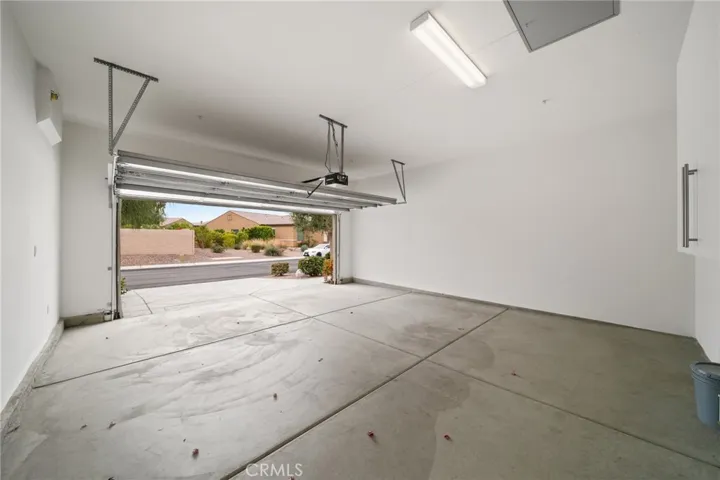 Spacious Two-Car Garage with Direct Street Access, Overhead Lighting, and Wall-Mounted Storage Cabinet