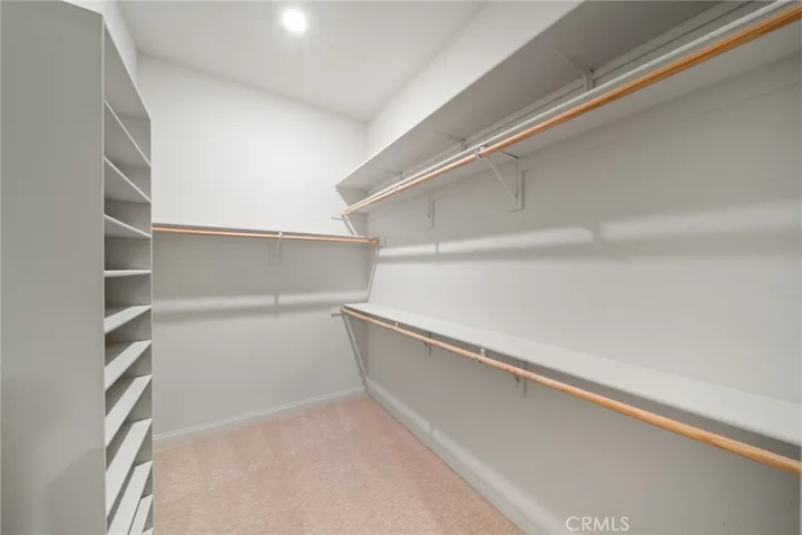 Spacious Walk-In Closet with Built-In Shelving and Ample Hanging Space