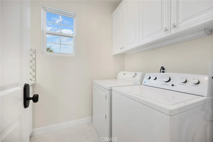 Upstairs laundry with sink and ample cabinets / storage on both sides