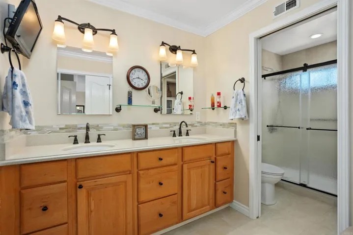 Recently remodeled primary en suite bathroom with dual vanities and walk-in closet.