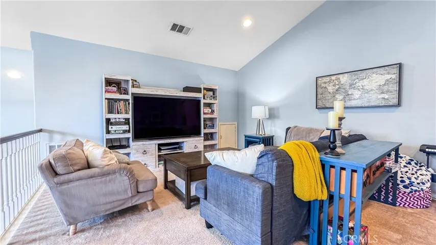 Loft area is  upstairs currently being used as a living room. It has an added feature with a ceiling fan and recessed lighting.