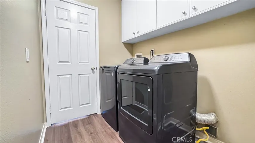The laundry room features lots of cabinets located on first floor with a hallway exiting to two car garage.  The Washer& Dryer are Included in Sale of house.