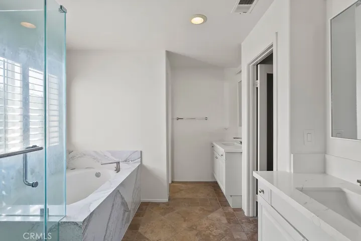 Spa inspired bathroom with updated quartz stone and travertine floors