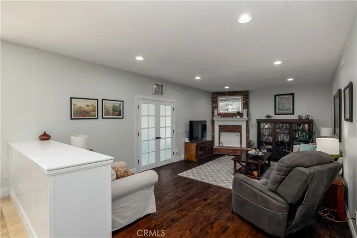 Family room with wood floors and wood burning fireplace.
