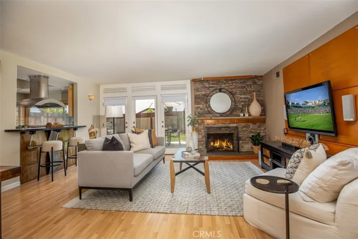 Cozy family room with stacked stone fireplace and screened french doors.