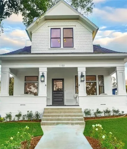 Front of house has large covered porch, and long driveway