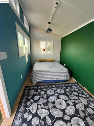 Bedroom featuring multiple windows and lofted ceiling