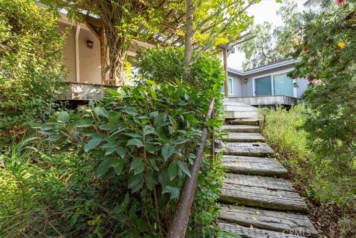 Wood stairs leading from the shop/apt up to the main house