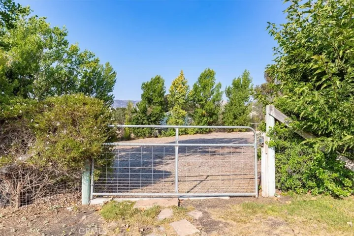 The orchard and lawn area is fenced off with a gate to the gravel side of the yard