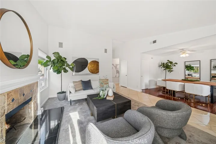 illuminating the spacious living room w/ its cozy fireplace