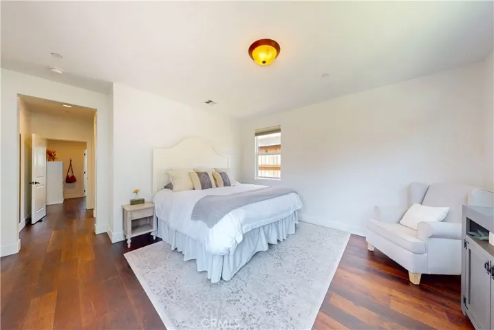 Primary bedroom features vinyl flooring and connects to a private bathroom and walk-in closet. 
