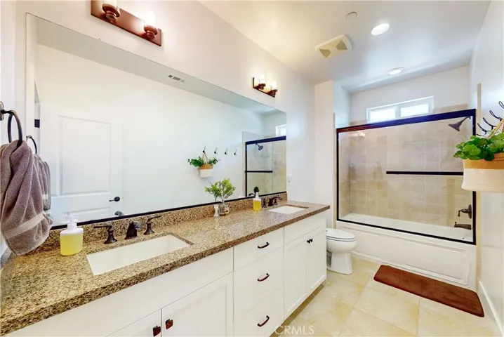 Upstairs bathroom with dual vanity and shower/tub combo.