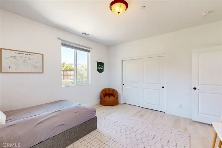 Upstairs Bedroom 2 features a sliding door closet and a large window overlooking the backyard.