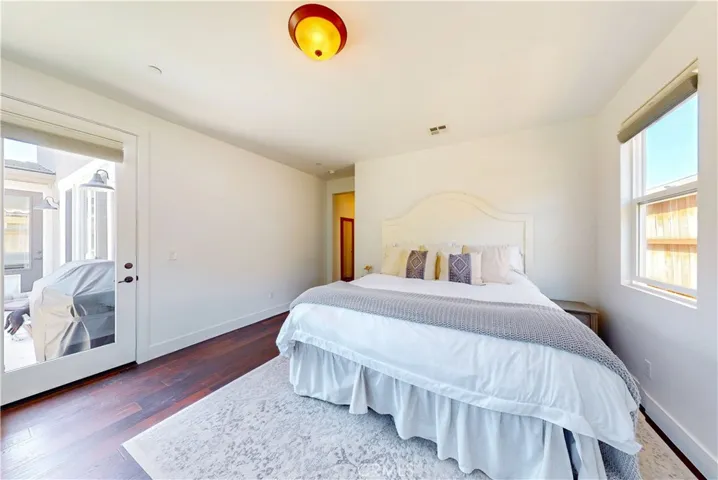 Large windows and glass door provide natural lighting and direct backyard access in primary suite.