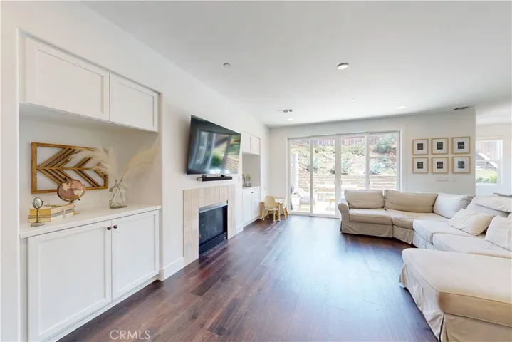 Living room featuring a gas fireplace and built in cabinetry for aesthetic yet practical storage.