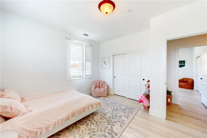Upstairs bedroom #2 showcases a sliding-door closet, planation shutters, and an ensuite bathroom.