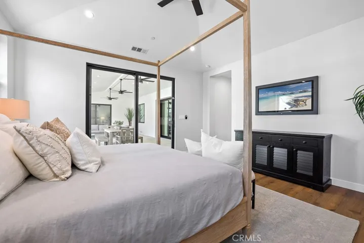 The elegant primary suite is a true retreat, complete with rich wood floors, soft lighting, and a calming neutral palette.