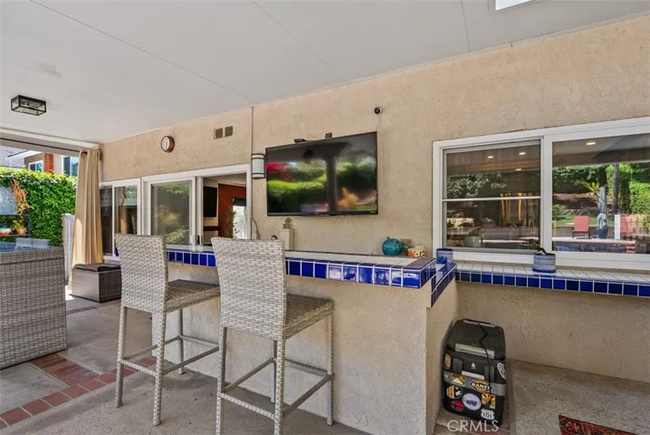 Custom bar with outdoor sink & fridge.