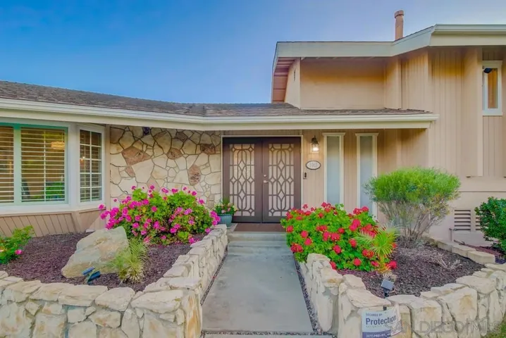 Lush bright flowers and impeccably manicured front yard greets you!
