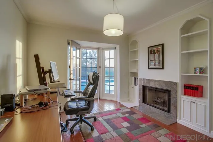 Great bedroom or office area with decorative fireplace and door out to backyard!