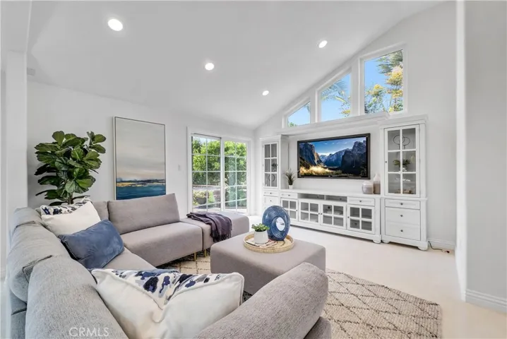 Family room with vaulted ceiling, recessed lighting, and custom built-in entertainment center