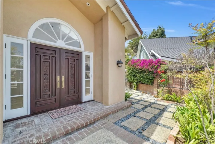 Gated Private Front Courtyard and Double Door Entry with Opening Sidelights, and Palladium Transom Window Above Door