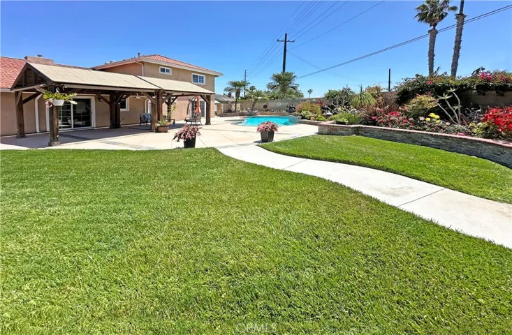 The home's crown jewel: a show-stopping park-like backyard oasis that rivals a lavish wedding venue, complete with lush lawn, vibrant gardens, sparkling pool & spa, tranquil fountain, raised brick planters, enchanting gazebo, and large covered patio perfect for entertaining & outdoor dining.