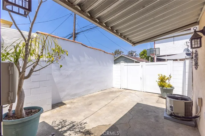 Awning covering back door and gated fence opens to alley
