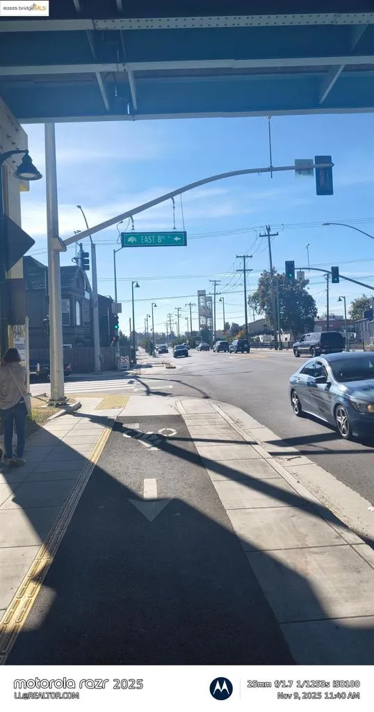 View of asphalt road with sidewalks, curbs, street lights, and traffic lights
