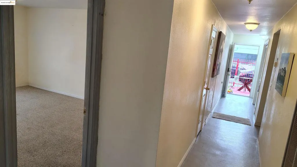 Hall with a textured wall and light colored carpet