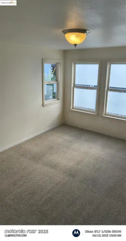 Carpeted spare room with a textured ceiling and baseboards