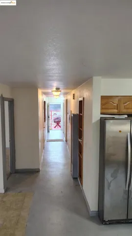 Hall featuring a textured ceiling and concrete floors