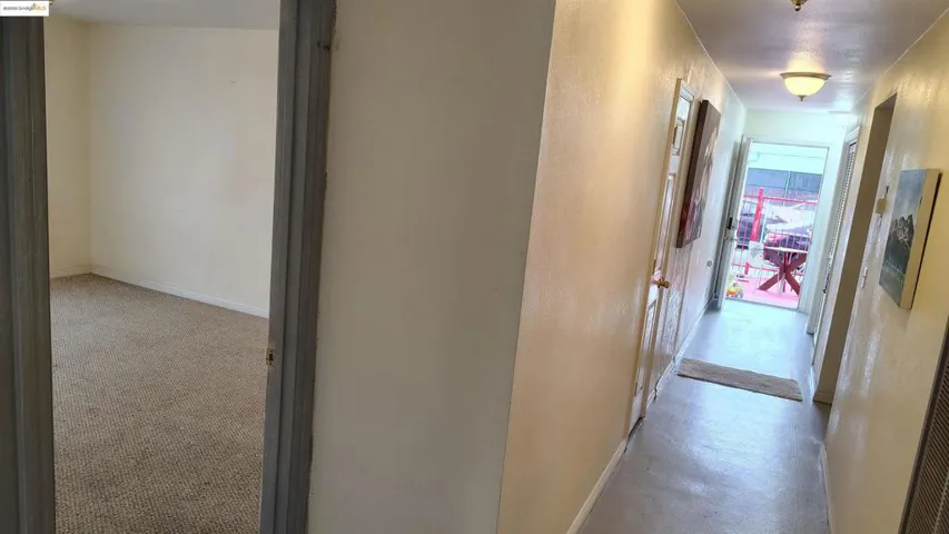 Hall with a textured wall and light colored carpet