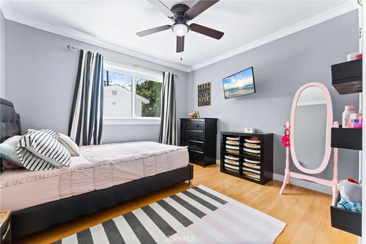 Bedroom #4 has wood flooring, ceiling fan, crown moulding, and large window overlooking the backyard!
