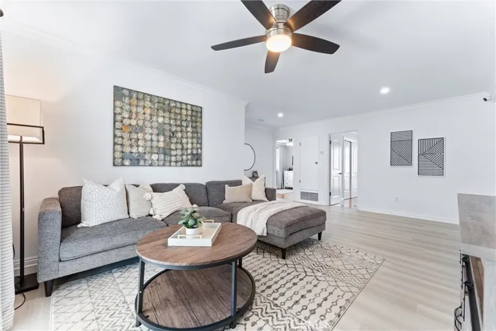 Family room with new LVP flooring, paint, recessed lighting, and ceiling fan.